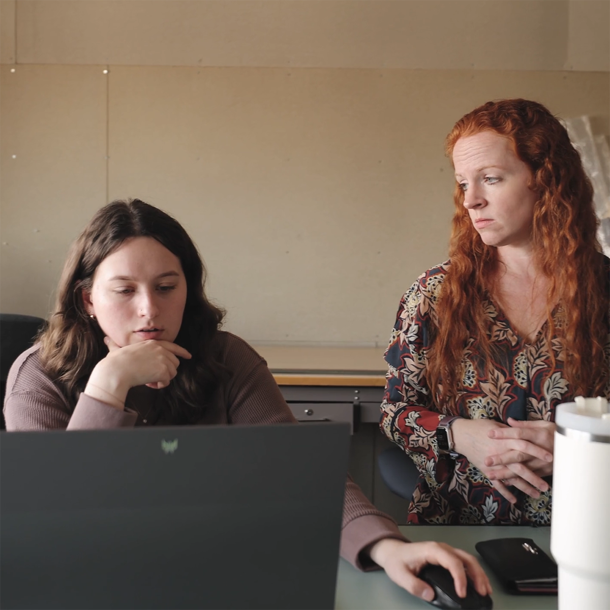 Photo of a faculty member and student talking together in a classroom